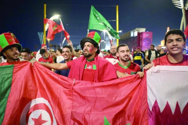 جماهير مغربية تهتف لمنتخبها في أحد ميادين الدوحة (أ.ف.ب)
