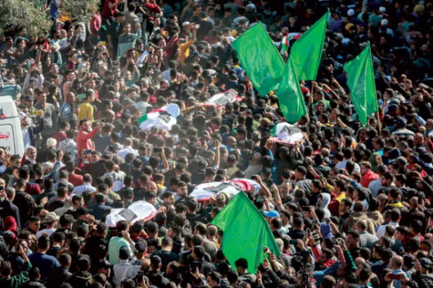 فلسطينيون يشاركون في تشييع ضحايا الحريق في قطاع غزة أمس (د.ب.أ)