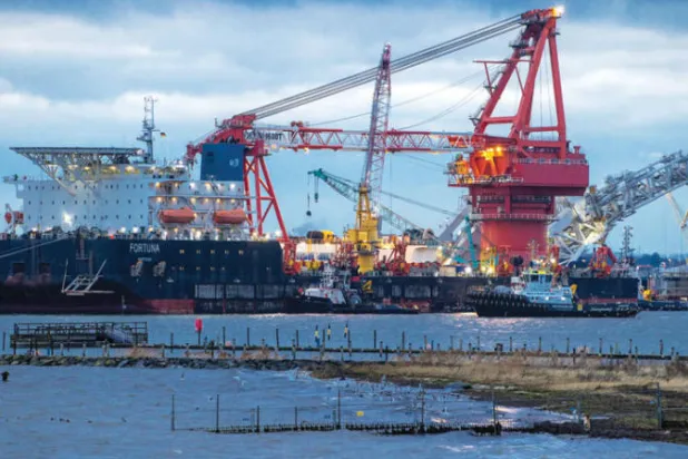أعمال تشغيلية على سفينة للغاز في ميناء فيسمار الألماني (أ.ب)