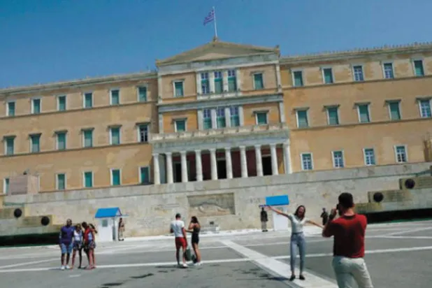 يونانيون يحتفلون بخروج بلادهم من الرقابة المالية الصارمة لاقتصادها بعد 12 عاماً من الألم (رويترز)