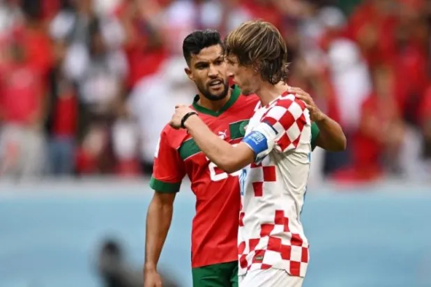 يحيى عطية الله لاعب المغرب في حديث مع الكرواتي مودريتش بعد نهاية اللقاء (رويترز)