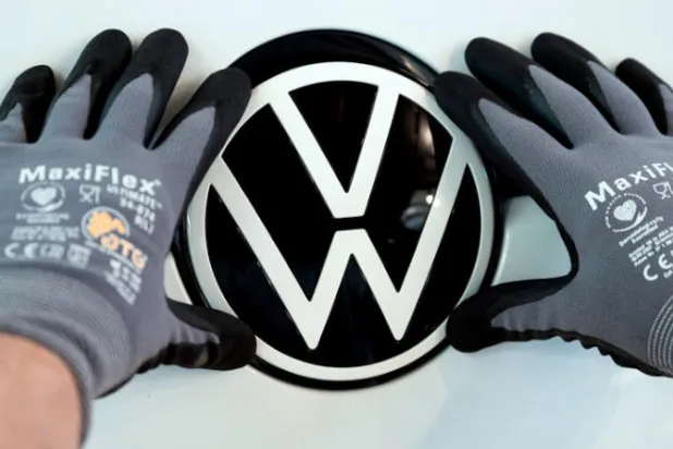 عامل في شركة "فولكسفاغن" يثبت علامتها التجارية على احد السيارات في مصنعها بألمانيا (د ب أ)