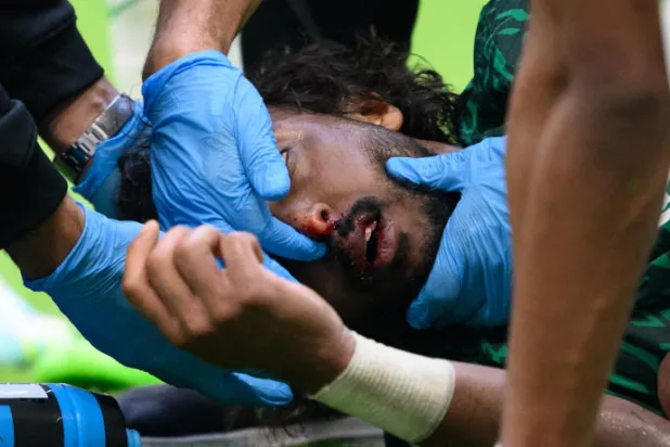 مدافع المنتخب السعودي تلقى ضربة هائلة خلال اشتراك مع الحارس محمد العويس (د.ب.أ)