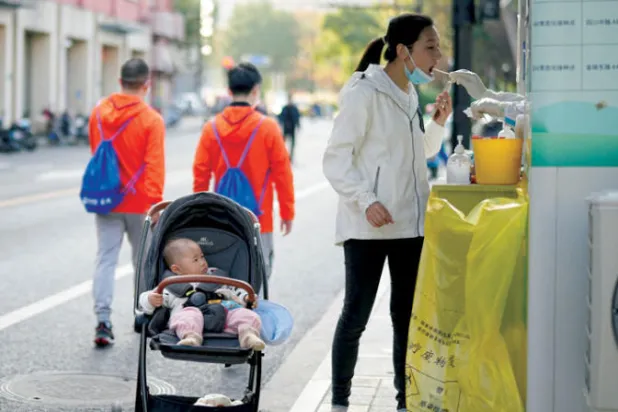 صينية تجري فحصاً لـ«كوفيد - 19» في أحد شوارع مدينة شنغهاي (رويترز)