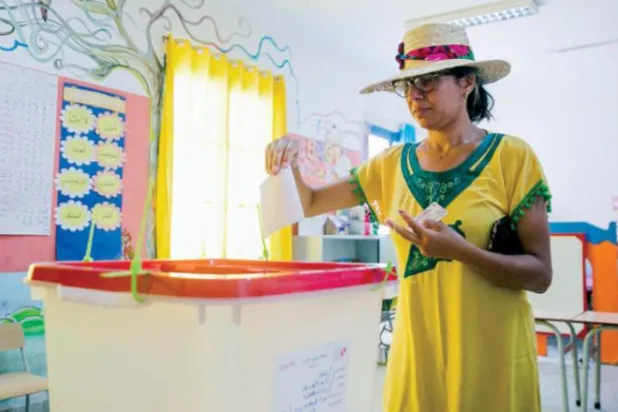 Tunuslu bir kadın geçen yaz yeni anayasa referandumunda oy kullanırken (AFP)