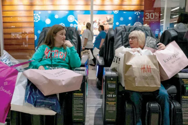 أميركيتان تأخذان لحظة للراحة في الجمعة السوداء في مركز للتسوق بناشفيل في ولاية تينيسي (أ.ف.ب)