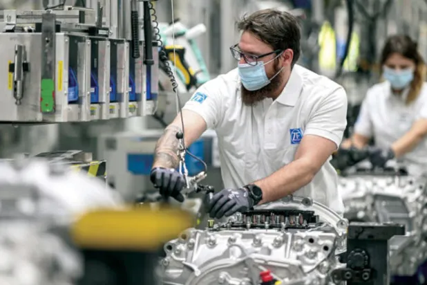 عامل على خط إنتاج في مصنع ماكينات ثقيلة بألمانيا (رويترز)