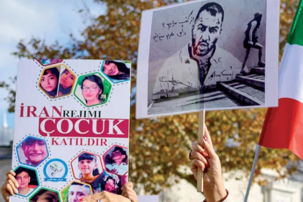 أشخاص يحملون صورتين لمغني الراب توماج صالحي والأطفال القتلى في الاحتجاجات الإيرانية خلال مسيرة لدعم النساء الإيرانيات في إسطنبول السبت 26 نوفمبر 2022 (أ.ف.ب)