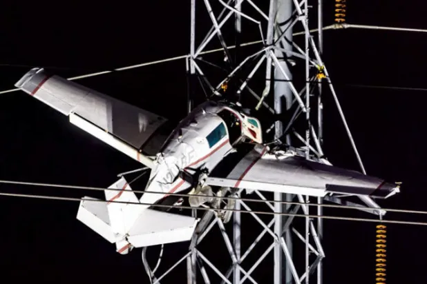 طائرة معلقة على خطوط الكهرباء (إ.ب.أ)