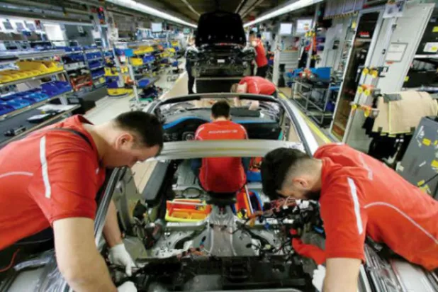 عمال على خط إنتاج سيارات في أحد المصانع الألمانية (رويترز)
