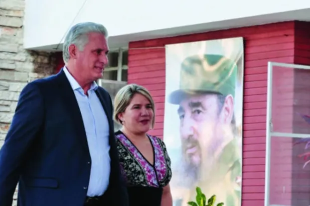 الرئيس ميغيل دياز - كانيل وزوجته ليس كويستا يدخلان مركز اقتراع للإدلاء بصوتيهما (رويترز)