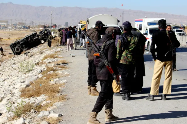 رجال أمن يعاينون مكان التفجير الانتحاري قرب مدينة كويتا، أمس (إ. ب. أ)