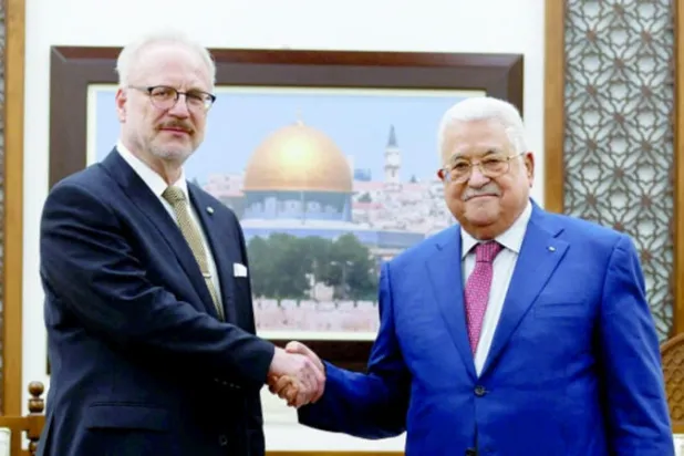 عباس مصافحاً لافتيس قبل اجتماعهما في رام الله أمس (رويترز)