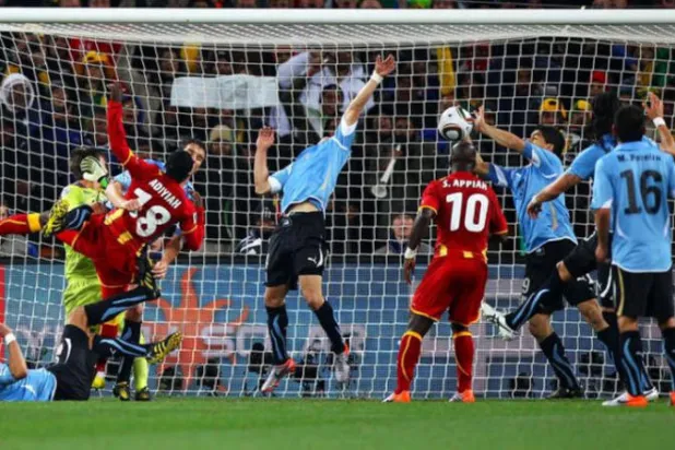 سواريز يمنع هدفاً لغانا، بعدما أبعد بيده ضربة رأس من دومينيك أدييا من على خط المرمى في مونديال 2010 (غيتي)