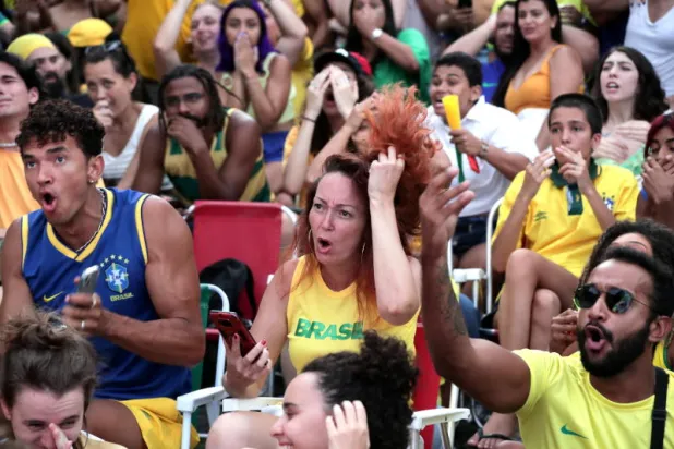 مشجعون برازيليون يشاهدون مباراة جمعت بين منتخبهم والكاميرون خلال نهائيات كأس العالم (إ.ب.أ)