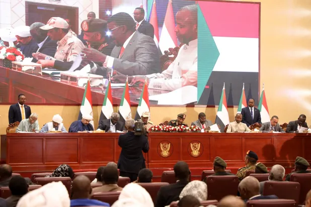 Sudanese army general Abdel Fattah al-Burhan (C) and leaders of civilian groups sign documents of a framework agreement to end the political stalemate in Khartoum, Sudan, 05 December 2022. (EPA)