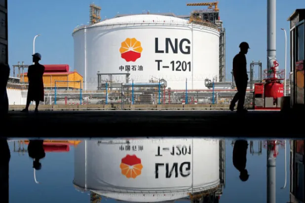 خزان للغاز الطبيعي المسال وعمال في محطة بتروتشاينا الغازية بميناء نانتونغ الصيني (رويترز)