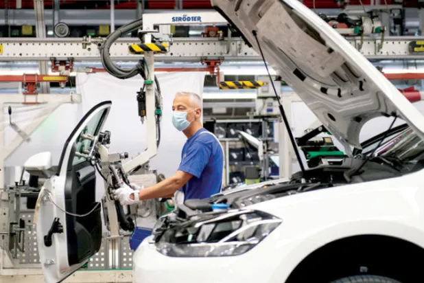 عامل  في خط تجميع «فولكس فاغن» بفولفسبورغ بألمانيا (رويترز)