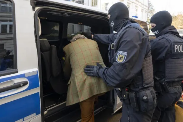 Alman memurlar Reich Vatandaşları bünyesindeki aşırı sağcı bir gruba yönelik baskınlar kapsamında Frankfurt’ta bir adamı gözaltına alıyor (Reuters)