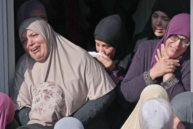 فلسطينيات يبكين خلال تشييع أحد القتلى في قرية سلواد في الضفة أمس (أ.ف.ب)