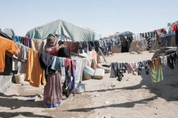 Sana’nın güneyinde yerinden edilmiş insanların kaldığı bir kampta Yemenli bir kadın kıyafetlerini asıyor (EPA)