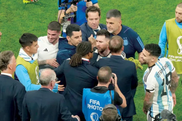 ميسي وإدغارد (مساعد مدرب هولندا) في مواجهة مشحونة بعد انتصار الأرجنتين بركلات الترجيح (د.ب.أ)