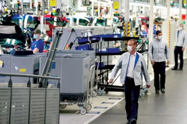 عمال يراقبون خطوط الإنتاج بأحد مصانع الماكينات في ألمانيا (رويترز)