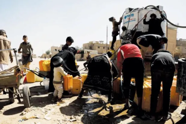 Yemenliler, Sana'nın eteklerinde bir bağışçı tarafından sağlanan tankerden temiz su almak için toplanıyor (EPA)