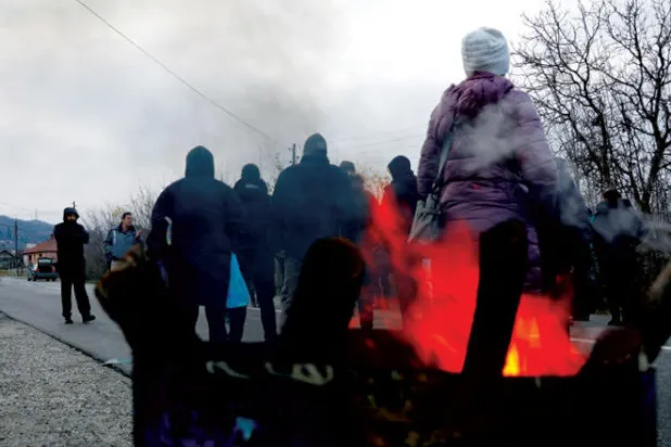 صرب يقطعون طريقاً قرب بلدة في شمال كوسوفو، أمس (رويترز)