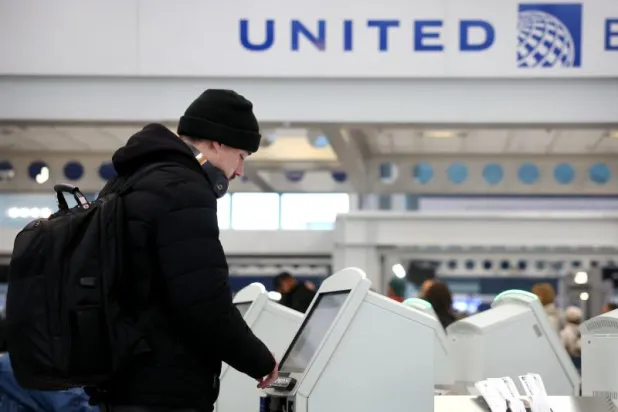 مسافر يقوم بتسجيل الوصول لرحلات الخطوط الجوية المتحدة في مطار أوهير الدولي (أ.ف.ب)