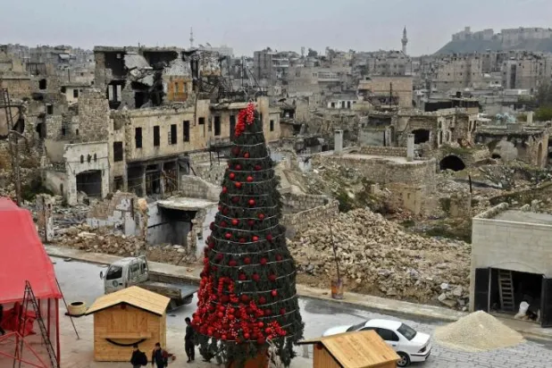 Workers set up a Christmas tree at al-Hatab square, one of the oldest in Syria's northern city of Aleppo, on December 12, 2022. (AFP)