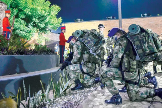 جنود كولومبيون يكرّمون ضحايا هجوم شنه متمردو «فارك» في كوكوتا يوم 9 ديسمبر الماضي (أ.ف.ب)