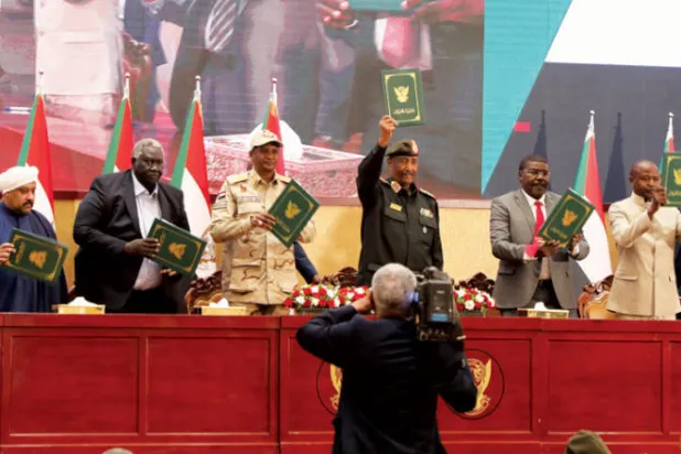 البرهان وممثلو القوى المدنية بعد توقيع الاتفاق السياسي في القصر الرئاسي بالخرطوم في 5 ديسمبر (إ.ب.أ)