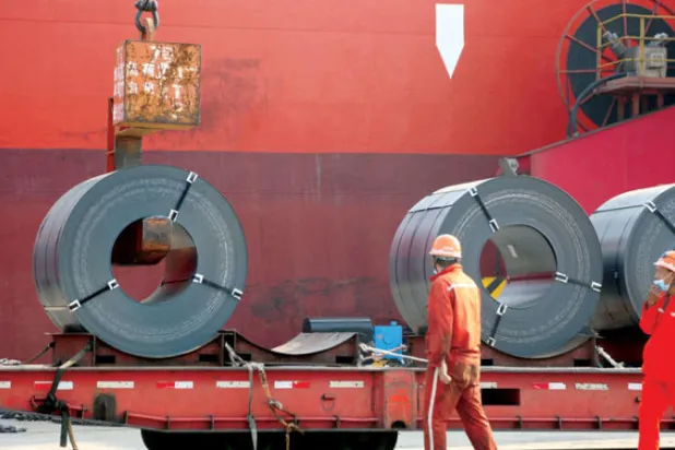 عمال يقومون بتحميل منتجات حديد صلب لتصديرها إلى سفينة شحن في الصين (رويترز)