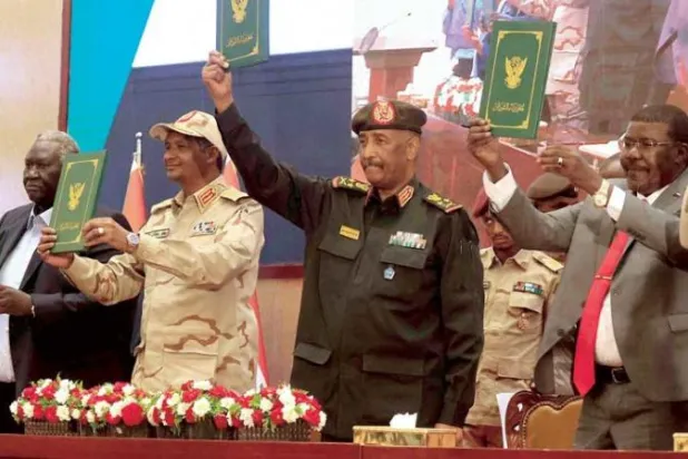 الموقعون على الاتفاقية الإطارية من قادة الجيش والمعارضة المدنية يلوحون بالوثائق في 5 ديسمبر (كانون الأول) 2022 (أ.ف.ب)