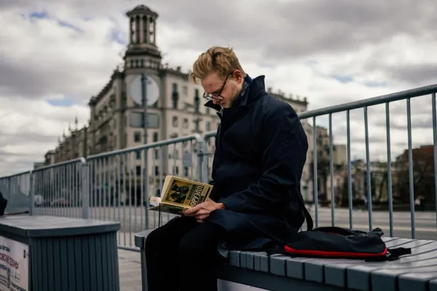 Moskova'nın Puşkin Meydanı'nda bir adam George Orwell'in 1984 kitabının Rusça çevirisini okuyor (AFP)

