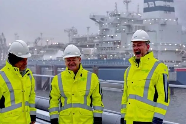 Almanya Başbakanı, Aşağı Saksonya eyaletindeki Wilhelmshaven gaz depolama terminalinin açılışı sırasında, gaz taşıyan özel bir geminin önündeki Maliye Bakanı ve Ekonomi Bakanı'nın arasında duruyor (EPA)