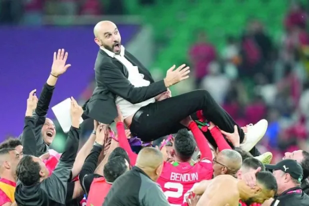 لاعبو المغرب يحتفلون بمدربهم بعد أن صعدوا للمربع الذهبي في المونديال (أ.ب)