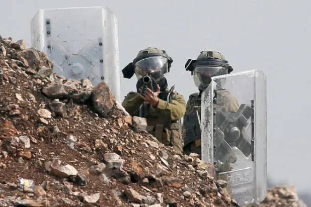 جنديان إسرائيليان خلال مواجهات مع فلسطينيين في قرية كفر قدوم بالضفة أمس (إ.ب.أ)