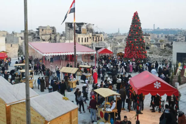 سوق أعياد الميلاد في ساحة الحطب بمدينة حلب عشية أعياد الميلاد (أ.ف.ب)