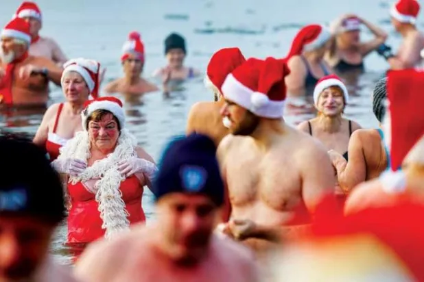 ألمان يمارسون طقس السباحة في المياه المثلجة في مدينة برلين احتفالاً بعيد الميلاد المجيد (إ.ب.أ)