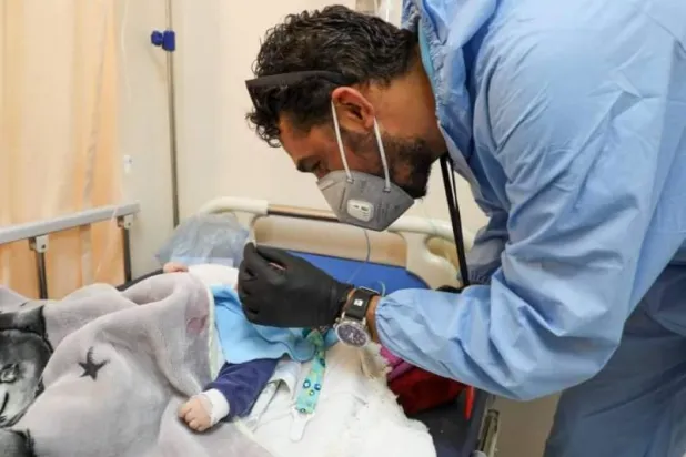 طبيب بمستشفى غريان المركزي التعليمي في ليبيا يفحص طفلاً يعاني من أعراض فيروس «التنفسي المخلوي» (إدارة المستشفى)