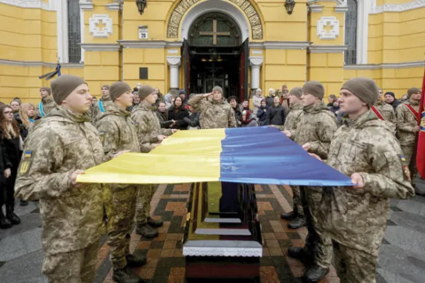 جنود أوكرانيون يودّعون جثمان أحد زملائهم قُتل في المعارك ضد الجيش الروسي (رويترز)