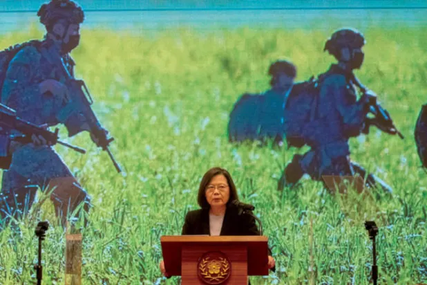 تساي إينغ - وين، رئيسة تايوان، تتحدث في مؤتمر صحافي وخلفها شاشة عملاقة تعرض فيلماً عن القوات المسلحة، أمس (إ.ب.أ)