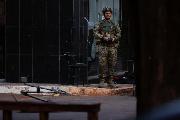 أحد أفراد قوات الأمن خلال العثور على حقيبة ظهر مثيرة للشكوك بالقرب من موقع تنصيب الرئيس البرازيلي لولا دا سيلفا (رويترز)