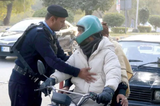 Pakistanlı güvenlik görevlisi, güvenlik alarmının ardından İslamabad'daki Marriott Hotel'in yakınlarında bulunan bir yol kenarındaki vatandaşları kontrol ediyor (EPA)