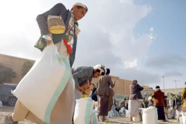 Sana'a'nın kuzeyindeki Amran’da yaşayan bir Yemenli, bir yardım kuruluşu tarafından sağlanan gıda yardımını alırken (EPA)