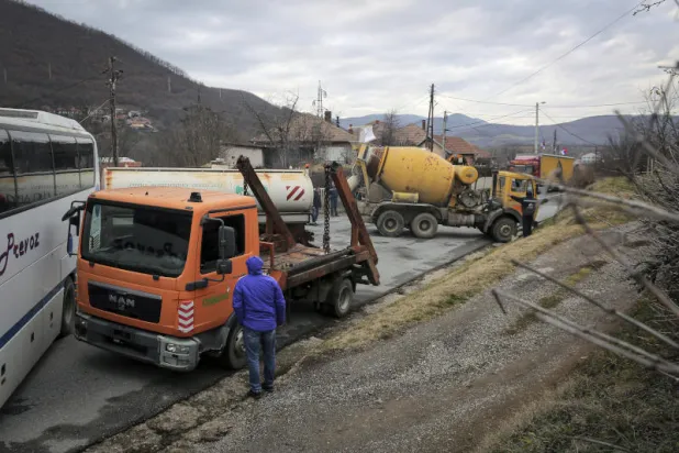المحتجون الصرب يزيلون الشاحنات من أحد الحواجز (أ.ب)