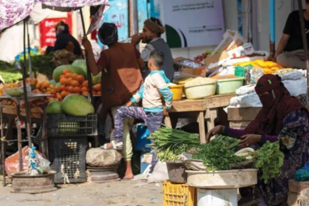 Taiz şehrinde bir pazarda müşterilerini bekleyen Yemenli bir kadın (AFP)