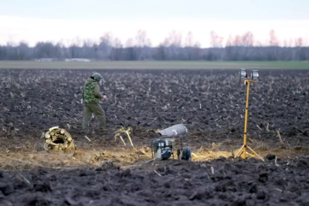 محقق عسكري يتفقد شظايا صاروخ في بيلاروس في 29 ديسمبر (إ.ب.أ)